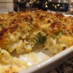 Close-up of a baked Chicken Divan casserole with a crispy, golden breadcrumb topping and creamy filling showing chicken and broccoli.