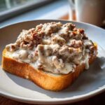 A thick slice of golden toast generously topped with creamy chipped beef on toast gravy.