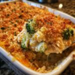 A spoonful of creamy Chicken Divan casserole featuring chicken, broccoli, and a golden brown breadcrumb topping.