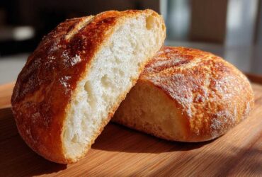 Close-up of a rustic loaf cut in half, showing the airy interior perfect for bread bowls.