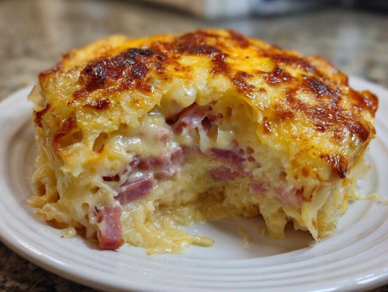 A close-up shot of a portion of homemade Reuben bake, showing melted cheese topping and chunks of corned beef inside.