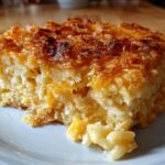 A close-up of a serving of cheesy potato casserole with a golden, crispy, baked cheese topping.