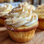 A close-up of a delicious banana pudding cupcake topped with creamy frosting and brown sugar crumbs.