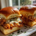 Close-up of two irresistible bbq chicken sliders topped with melted white cheese and parsley.