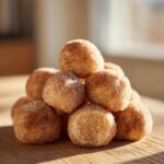 A stack of freshly made cinnamon sugar snowball cookies coated in sparkling sugar and cinnamon mix.