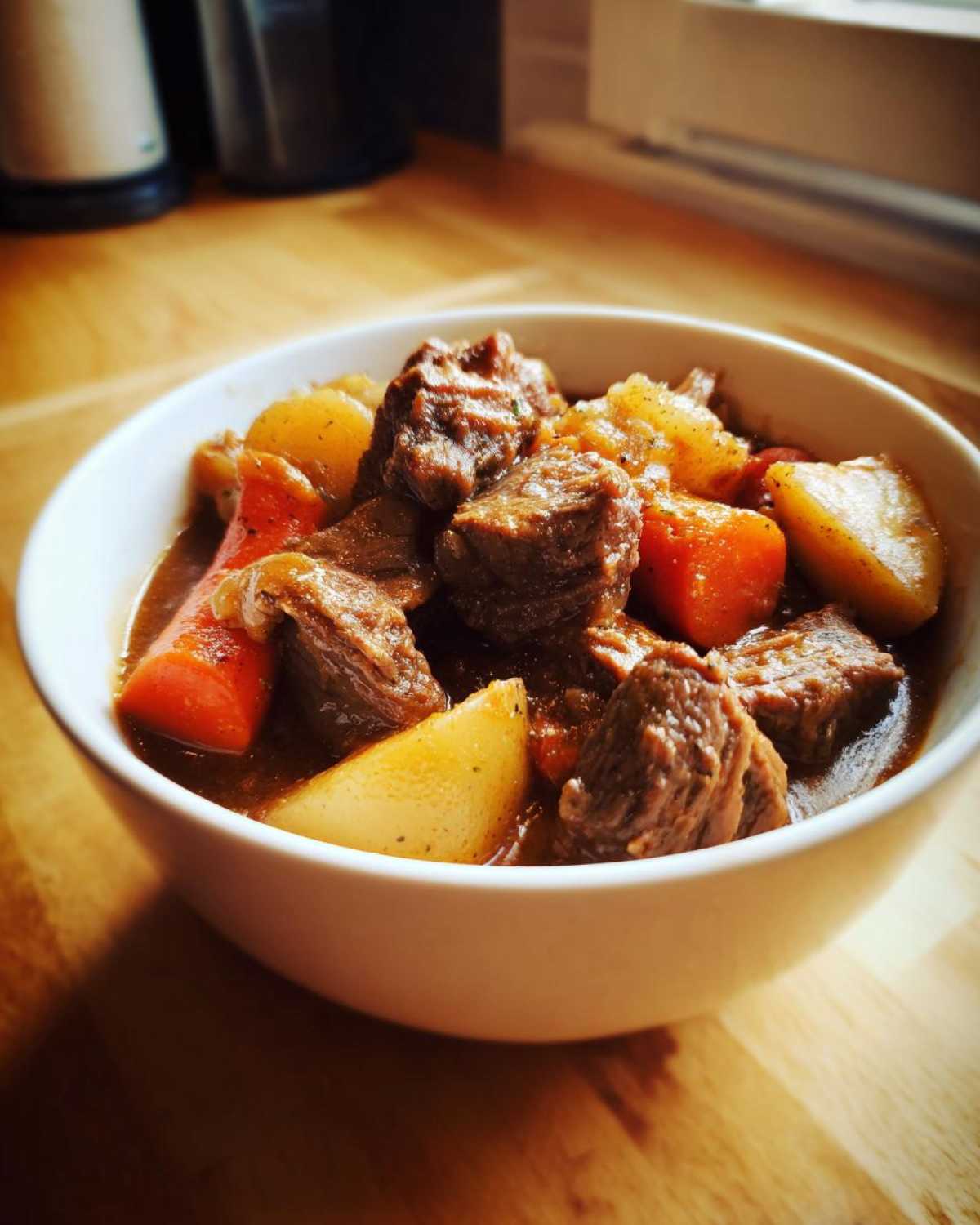 Close-up of tender beef chunks, potatoes, and carrots in a rich gravy, perfect crockpot beef stew.