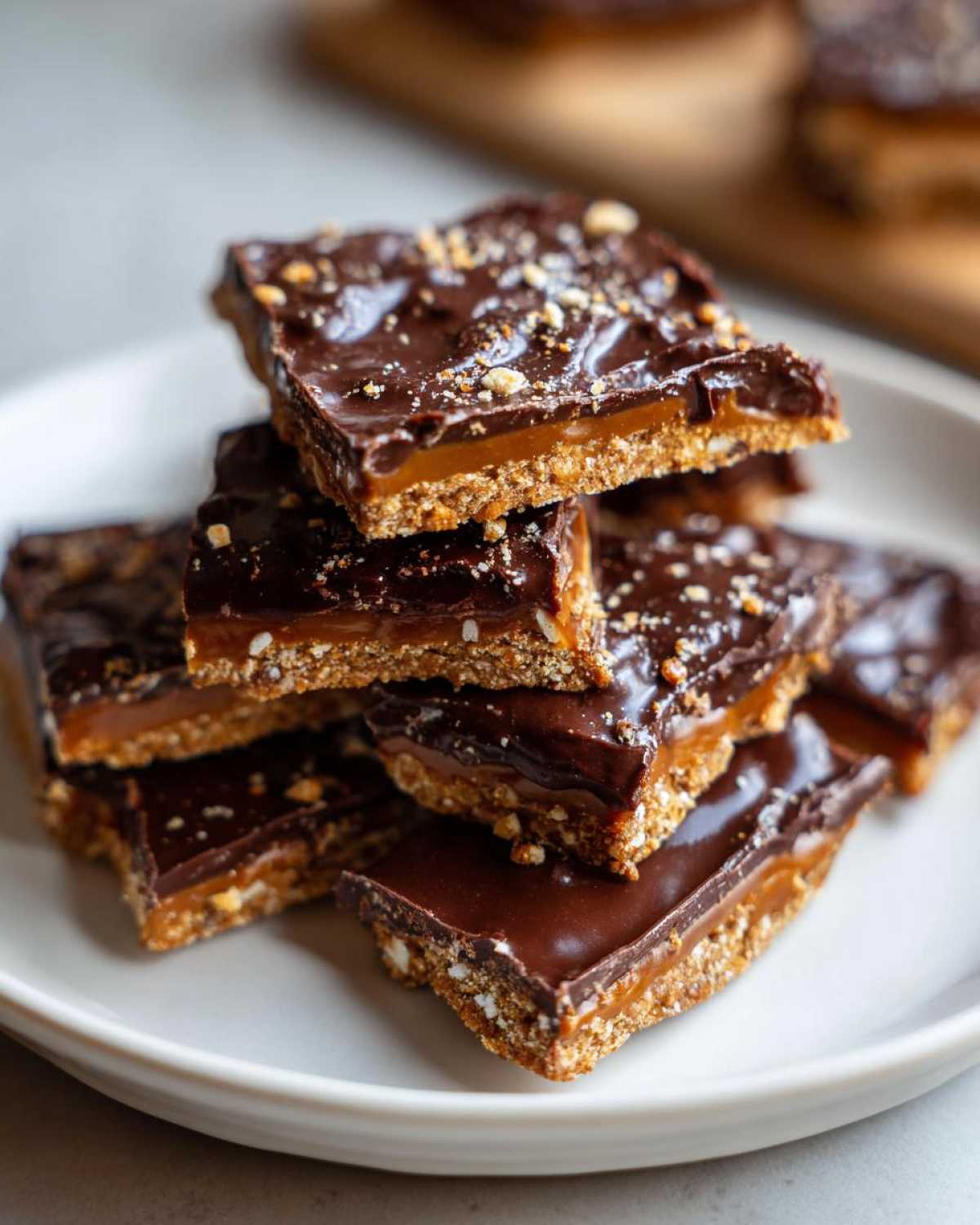 A stack of rich graham cracker toffee squares with a thick chocolate topping and visible caramel layer.