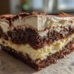 Close-up of a decadent slice of Italian love cake showing rich chocolate layers and creamy filling, dusted with cocoa.