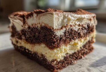 Close-up of a decadent slice of Italian love cake showing rich chocolate layers and creamy filling, dusted with cocoa.