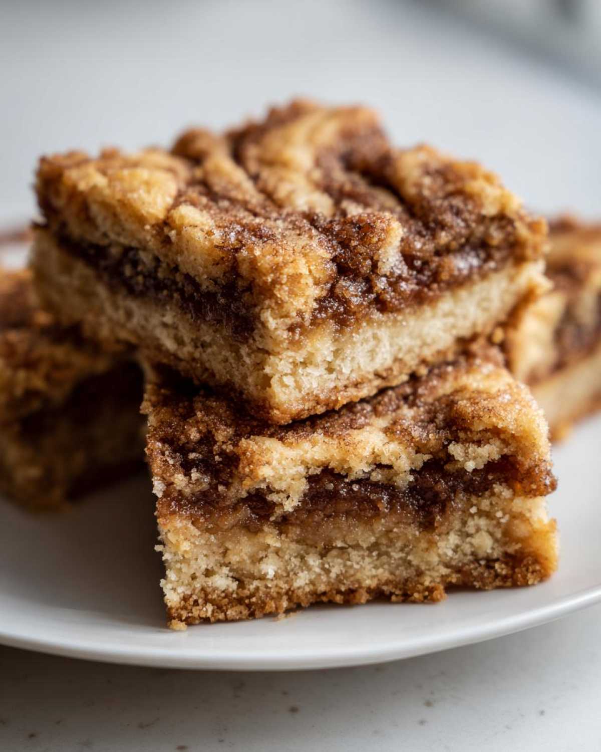Close-up of stacked snickerdoodle blondies squares showing a thick, chewy base and cinnamon swirl topping.