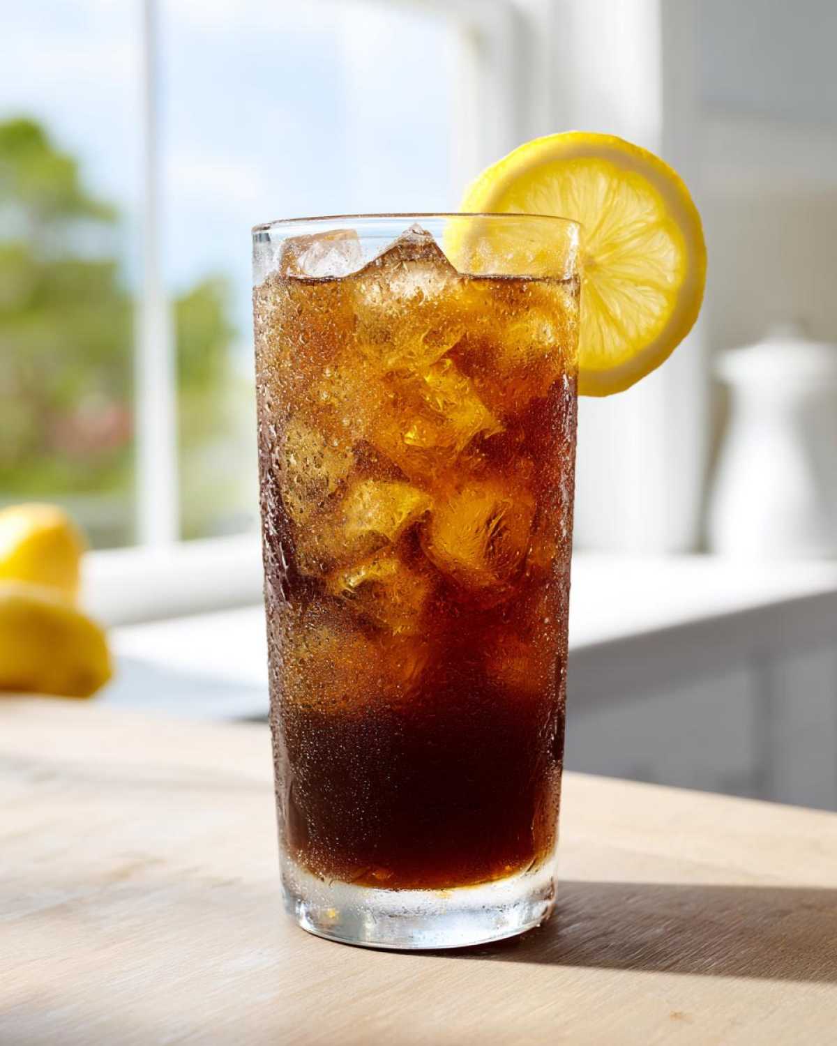 Tall glass filled with iced Cold Brew Lemonade, garnished with a lemon slice.