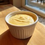 A small white ramekin filled with thick, creamy, yellow Copycat Taco Bell Chicken Quesadilla Sauce.