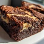 Close-up of a fudgy Dark Chocolate Tahini Brownies square showing a creamy tahini swirl.