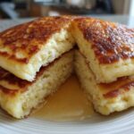 Close-up of fluffy Gluten-Free Buttermilk Pancakes cut open, showing the interior texture and syrup.
