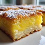 A close-up of a square Gluten-Free Lemon Bars with Shortbread Crust, topped with powdered sugar.
