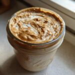 Close-up of High-Protein Peanut Butter Overnight Oats topped with swirled peanut butter and milk.