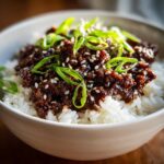 Close-up of Korean Ground Beef Bulgogi Bowls featuring savory ground beef over white rice, topped with sesame seeds and green onions.