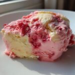 A close-up scoop of marbled Strawberry Banana Ice Cream showing swirls of pink strawberry and creamy yellow banana flavors.