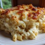 A close-up of a hearty serving of Cheesy Chicken Alfredo Bake with Mozzarella, featuring a golden-brown, bubbly cheese crust.