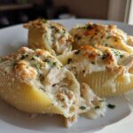 Close-up of baked Cheesy Chicken Stuffed Pasta shells topped with melted cheese and parsley.