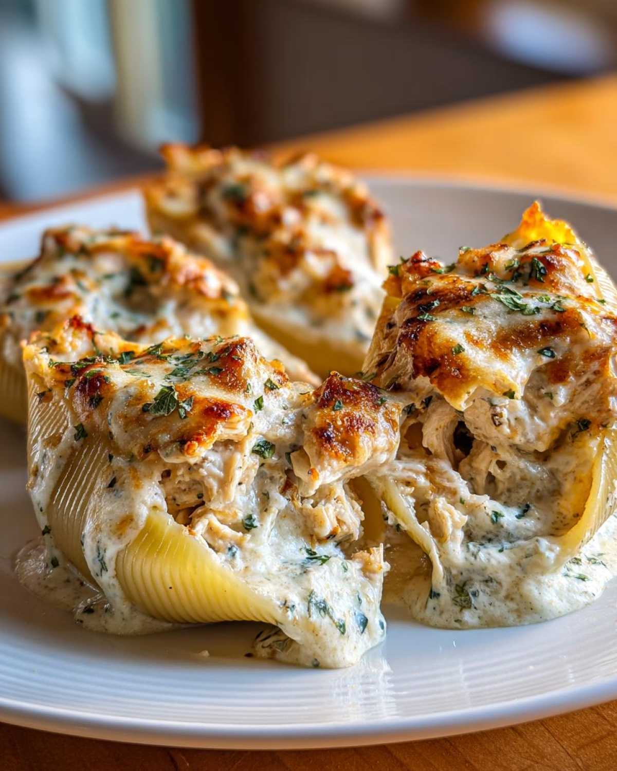 Close-up of baked Cheesy Chicken Stuffed Pasta shells overflowing with creamy sauce and melted cheese.