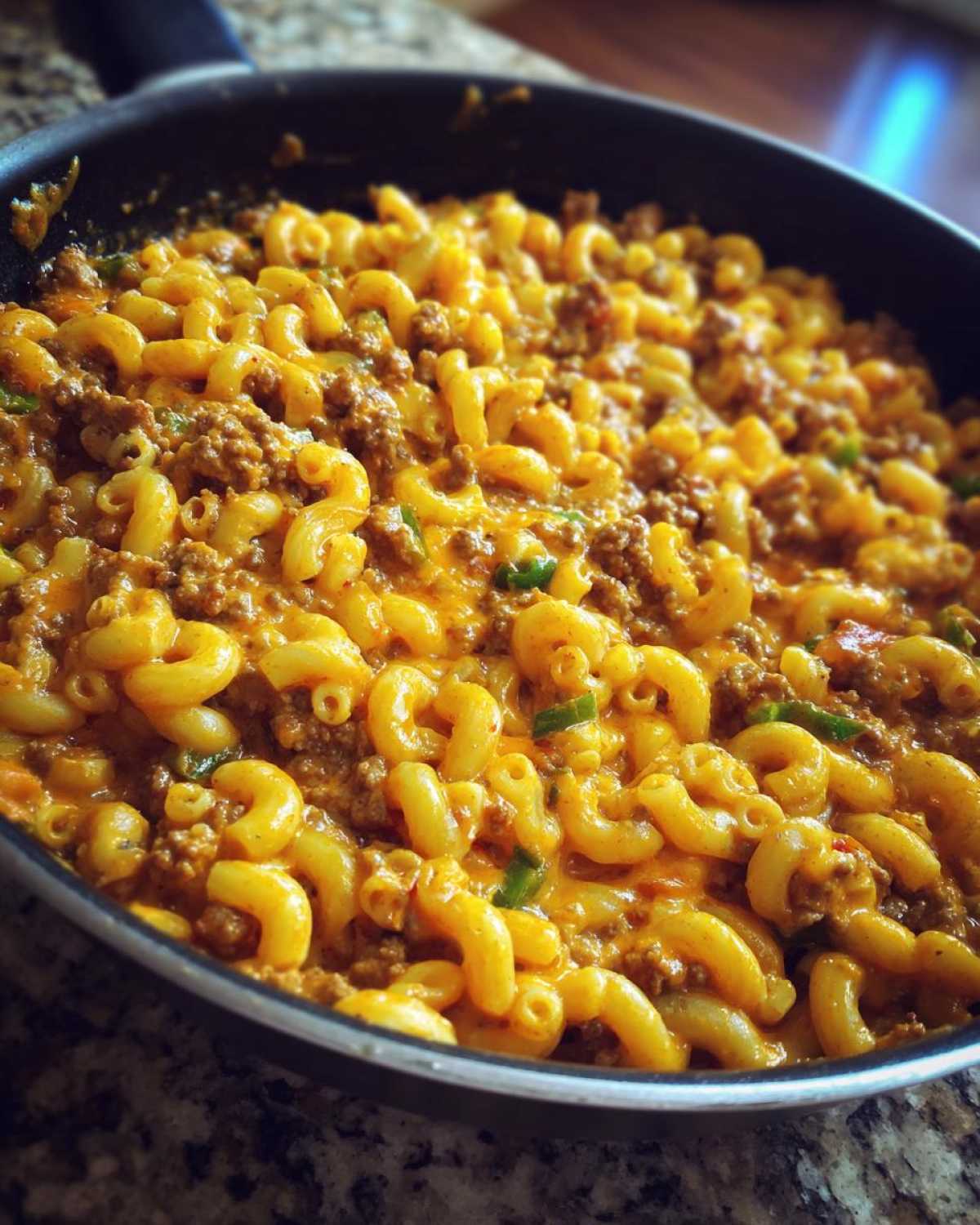 Close-up of Cheesy Taco Pasta One Pot Dinner Idea with elbow macaroni, seasoned ground beef, and melted cheese in a skillet.