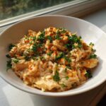A white bowl filled with Creamy Cajun Chicken Rice One Pot Meal, topped with fresh parsley.