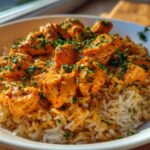 Close-up of a serving of Creamy Cajun Chicken Rice One Pot Meal, featuring seasoned chicken pieces in a rich sauce over rice, garnished with parsley.