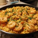Close-up of a skillet filled with Creamy Cajun Shrimp and Rice, topped with seasoned shrimp and fresh parsley.
