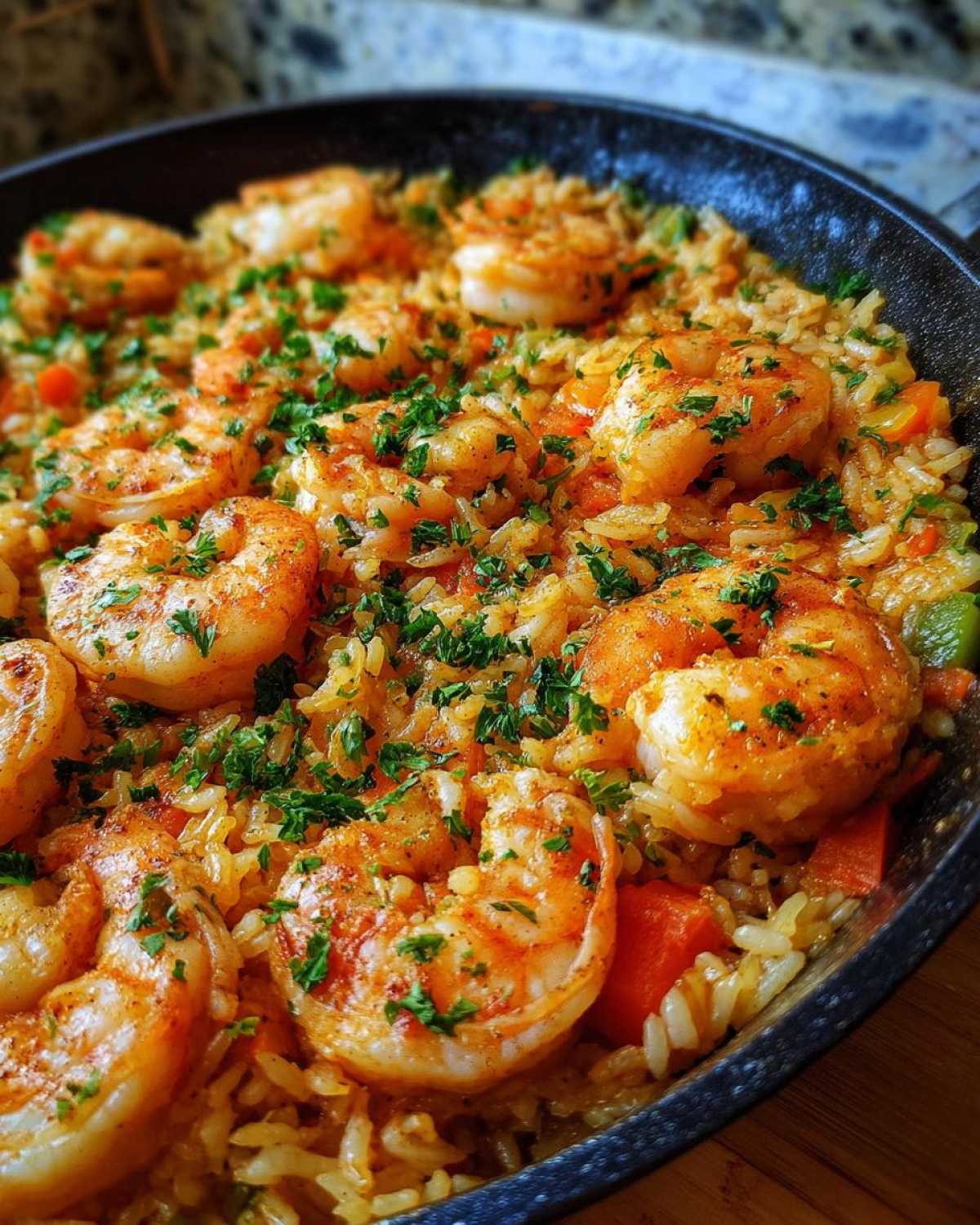 Close-up of perfectly cooked shrimp nestled in seasoned rice in a skillet, featuring Creamy Cajun Shrimp and Rice Skillet.
