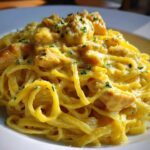 Close-up of a plate piled high with Creamy Lemon Chicken Pasta with Parmesan, garnished with parsley.
