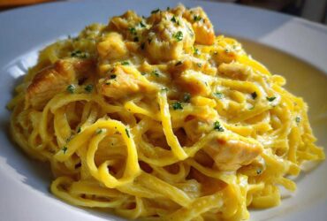 Close-up of a plate piled high with Creamy Lemon Chicken Pasta with Parmesan, garnished with parsley.
