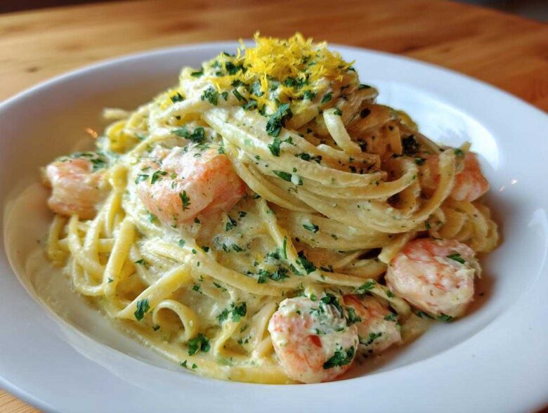 A close-up of rich Creamy Lemon Garlic Shrimp Pasta topped with fresh parsley and lemon zest.