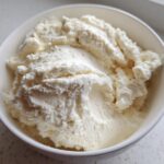 Close-up of a thick, white, creamy vanilla protein smoothie bowl base in a white bowl.