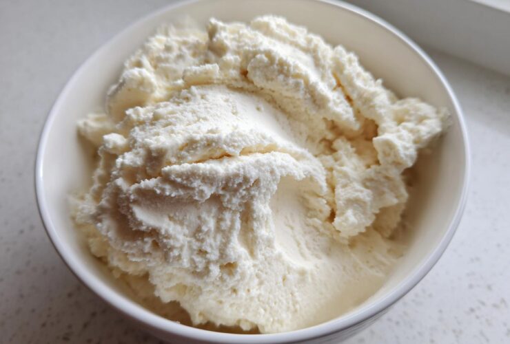 Close-up of a thick, white, creamy vanilla protein smoothie bowl base in a white bowl.