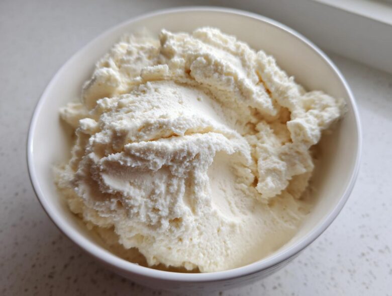 Close-up of a thick, white, creamy vanilla protein smoothie bowl base in a white bowl.