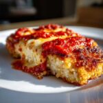 A close-up of a serving of Crispy Chicken Parmesan with Melty Cheese, topped with bright red marinara sauce.