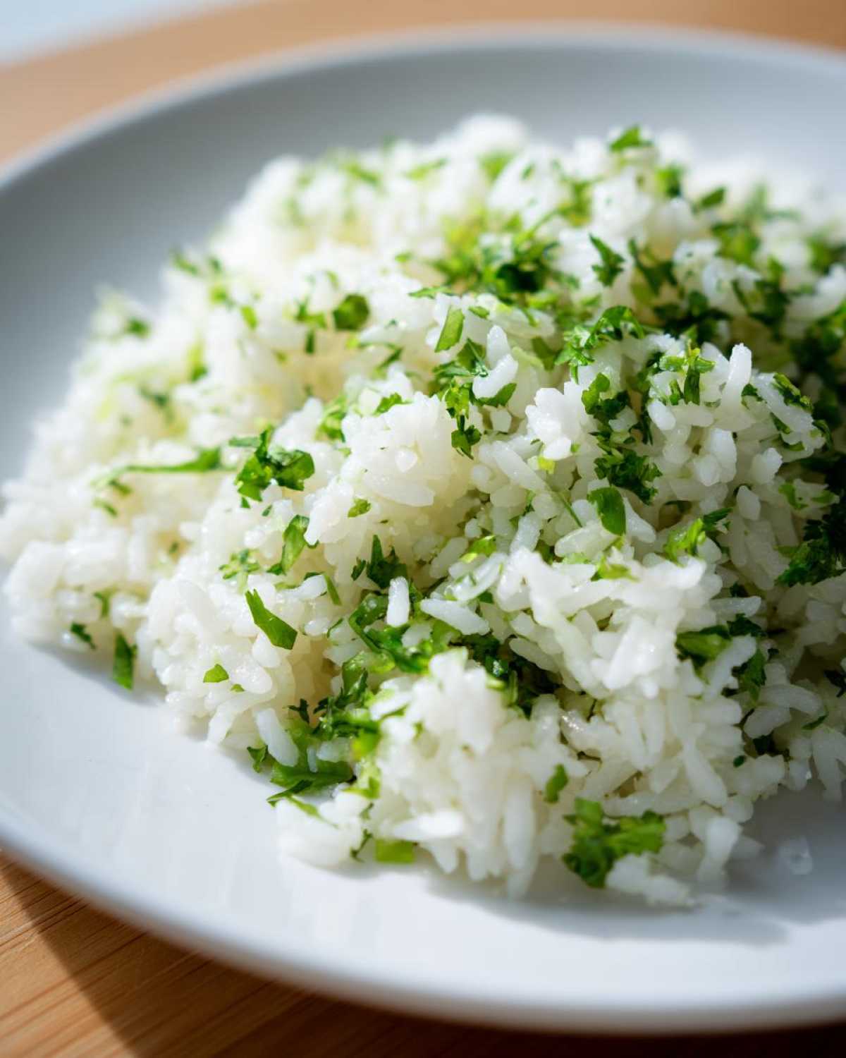 Close-up of fluffy white rice mixed with bright green chopped cilantro, perfect Cilantro Lime Rice for Burrito Bowls.