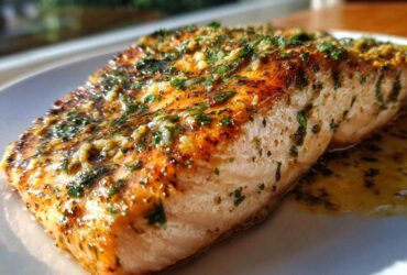 Close-up of a perfectly cooked Garlic Butter Salmon with crispy, browned skin and herbs.