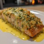 A perfectly cooked fillet of Garlic Butter Salmon with Lemon Garlic Sauce, topped with breadcrumbs and parsley.