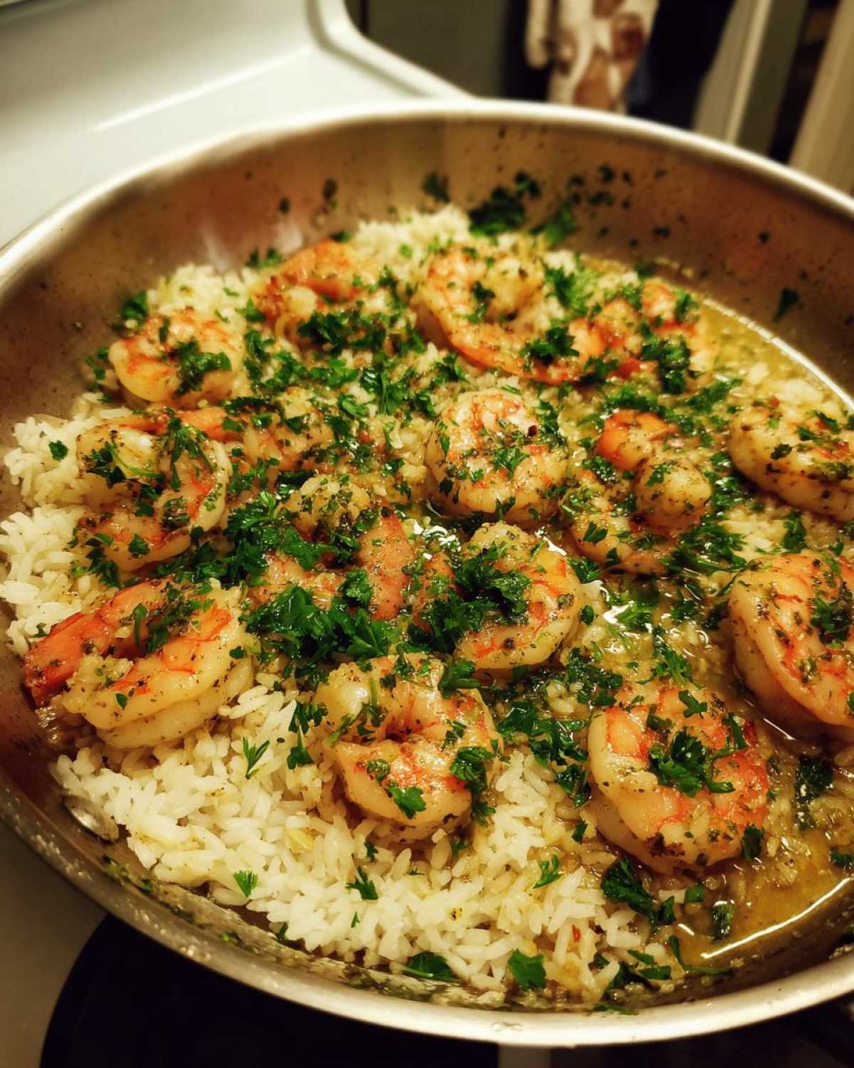 Close-up of Garlic Butter Shrimp and Rice Skillet topped generously with fresh chopped parsley.
