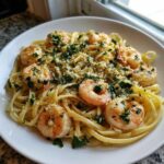A close-up of Garlic Butter Shrimp Pasta with Lemon Flavor, topped with shrimp and fresh parsley.