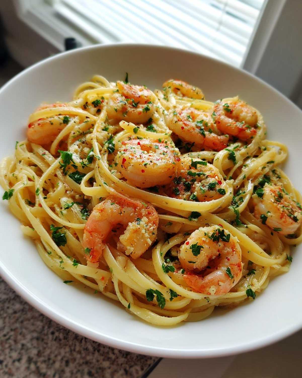 A close-up of Garlic Butter Shrimp Pasta with Lemon Flavor, featuring linguine tossed in sauce with plump shrimp and fresh parsley.