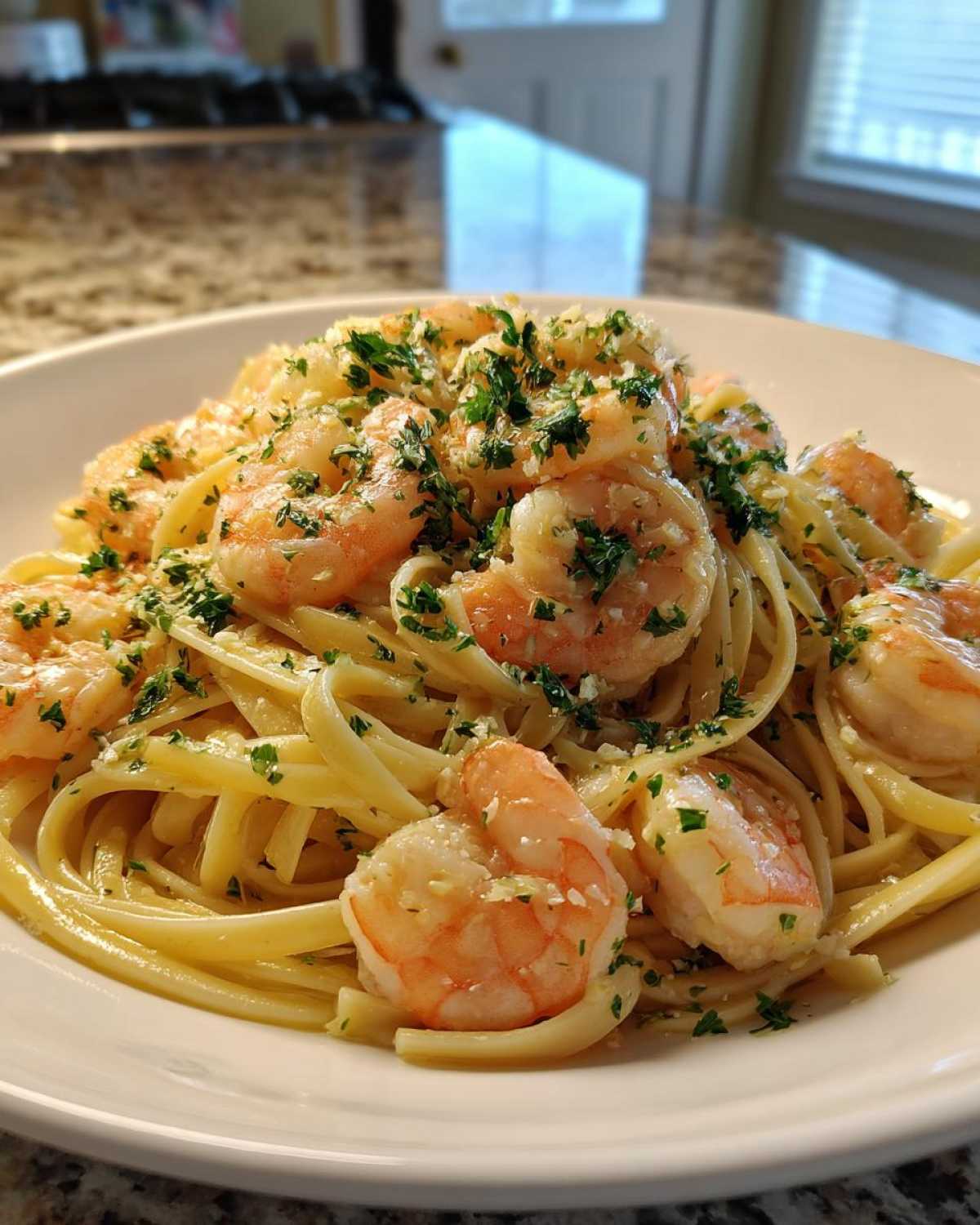 Close-up of Garlic Butter Shrimp Pasta with Lemon Flavor, featuring linguine tossed in sauce and topped with pink shrimp and fresh parsley.