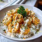 Close-up of a Garlic Butter Shrimp Rice Bowl topped with creamy garlic sauce and fresh parsley.