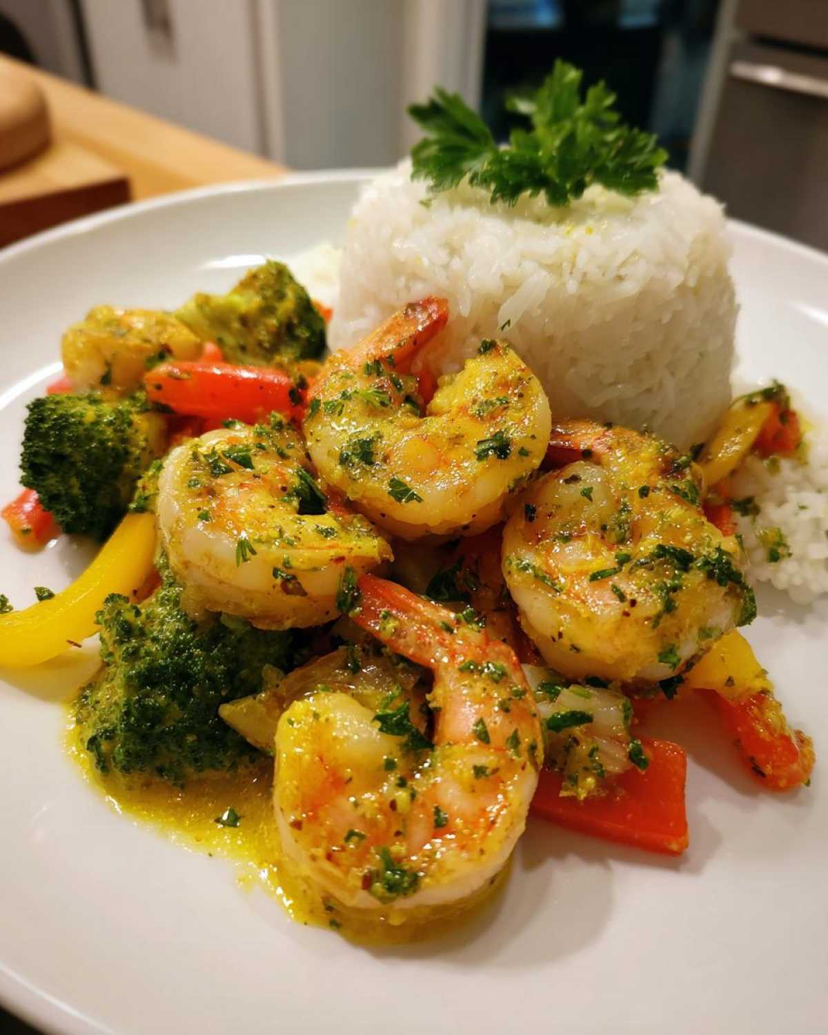 Plated portion of Garlic Butter Shrimp with Rice and Veggies, featuring large shrimp in yellow sauce next to white rice.