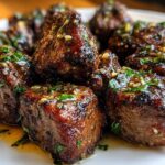 Close-up of perfectly seared Garlic Butter Steak Bites glistening with butter sauce and topped with fresh parsley.