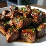 Close-up of tender Garlic Butter Steak Bites coated in sauce and topped with fresh parsley.