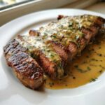 Perfectly cooked, sliced Garlic Butter Steak with Creamy Sauce drizzled over the top.