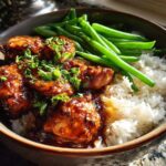 Close-up of a Honey Garlic Chicken Bowl featuring sticky glazed chicken pieces over white rice with steamed green beans.
